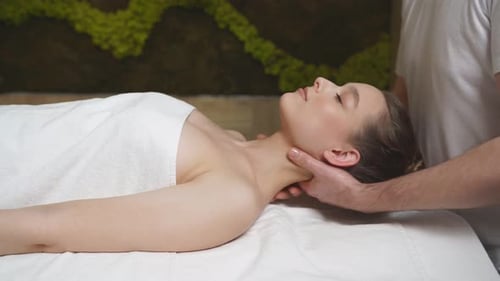 Professioneller Therapeut, der weiblichen Kundin eine gesunde Massage an Nacken und Schultern durchführt