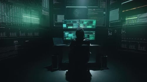 Hooded Hacker Working at Computer Terminal