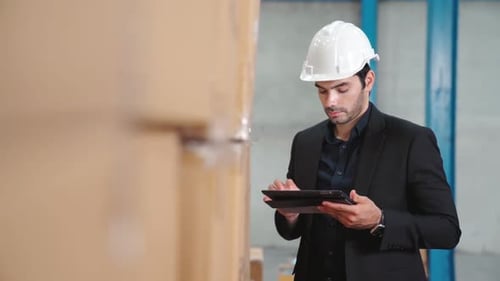 Factory Manager Using Tablet Computer in Warehouse or Factory