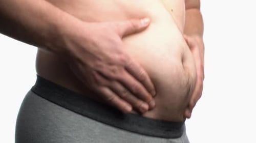 Homme obèse montrant son gros ventre
