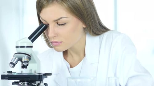 Female Chemist, Scientific Researcher using Microscope in Laboratory