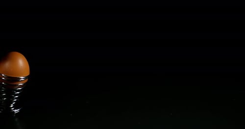 Eier- und Eierbecher, die auf schwarzem Hintergrund springen, Zeitlupe 4K