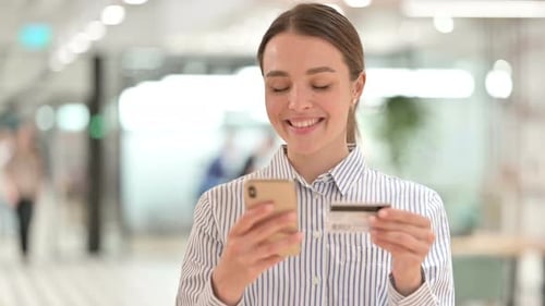 Woman Shopping Online with Mobile Phone and Credit Card