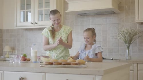 Happy Mother and Daughter Baking Cupcakes Together
