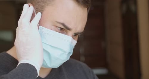 Adult Putting on Surgical Mask and Gloves