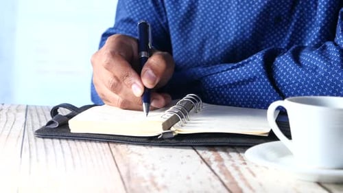 Close Up of Person Writing in Notebook