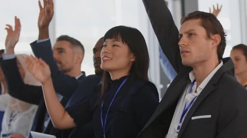 Adults Raising Hands at Corporate Conference