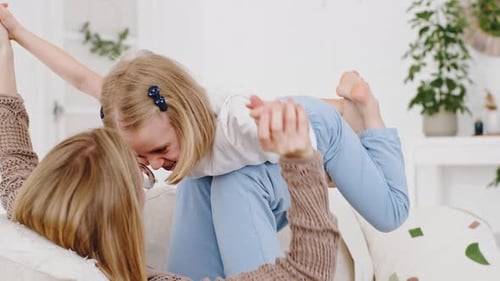 Mother Playing with Daughter on the Couch