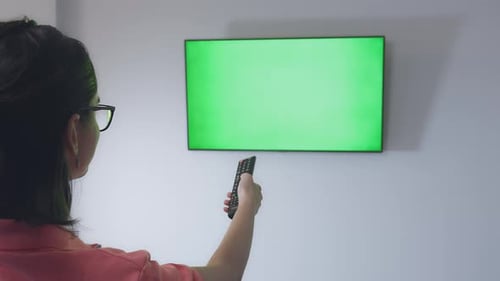 Woman Controls Green Screen Television with Remote