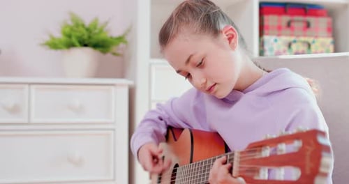 Girl Plays Guitar in Bright Room
