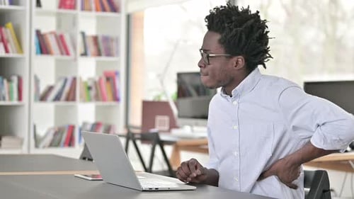 Man Working at Laptop Experiences Back Pain