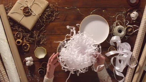 Woman Wrapping Christmas Gift with Festive Decorations