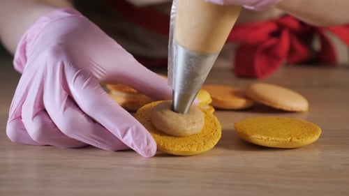 Filling Macarons with Creamy Frosting in Bakery