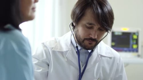 Doctor Listens to Patient Heart with Stethoscope