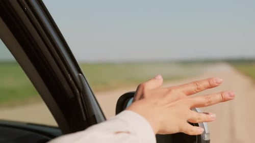 Woman's Hand Out Car Window Driving Country Road