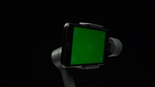 Steadicam with Green Screen on Smartphone Spinning Around Its Axis.