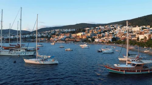 Yachten, die während des Sonnenuntergangs in der Bucht festgemacht sind. Ferienort Bodrum (Halikarnassos) mit weißen Häusern