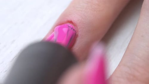 Applying Bright Pink Nail Polish in Close Up