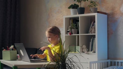 Girl Using Laptop Computer at Table Indoors