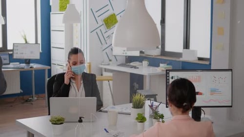 Travailleur indépendant avec masque de protection discutant au téléphone d'une nouvelle stratégie
