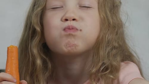 Blonde Child Chews on Carrot