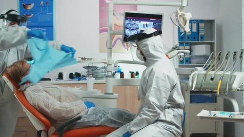Dentist Examines Patient with Protective Gear in Clinic