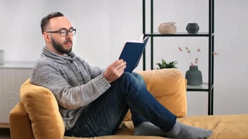 Man Relaxing at Home Reading Book