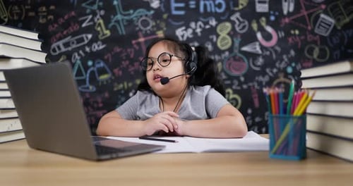 Girl Learns Online with Laptop and Headset