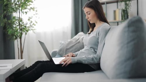 Woman Relaxing at Home Using Laptop Computer