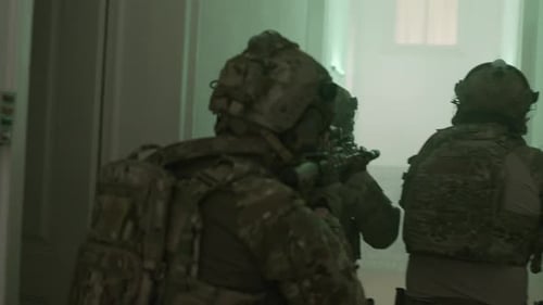 Soldaten gehen langsam die Halle des zerstörten Gebäudes hinunter