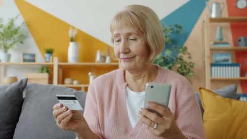 Senior Woman Shopping Online Making Electronic Payment with Bank Card and Smartphone