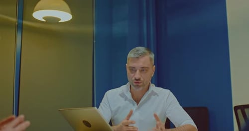Portrait a Young Grayhaired Businessman Holds a Meeting with Partners in the Office