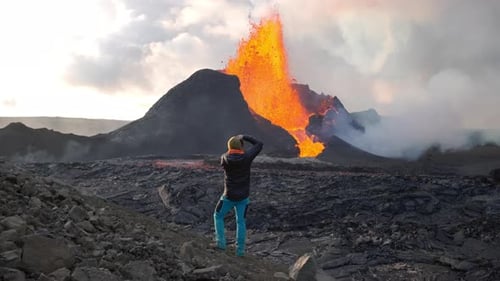 Man Photographing Lava Flowing From Erupting Fagradalsfjall Volcano