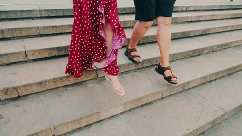 Legs of a Man and a Woman Going Down the Stairs