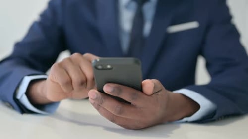 Hands of African Businessman Using Smartphone Close Up