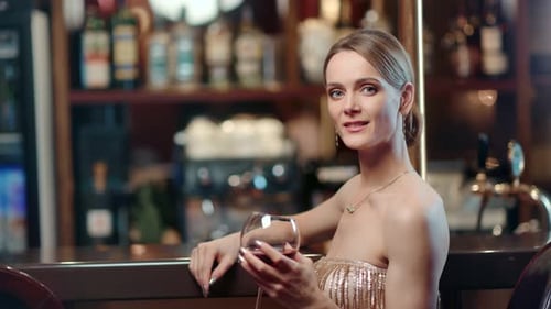 Beautiful Fashion Female Model Smiling Posing with Bocal of Wine at Bar