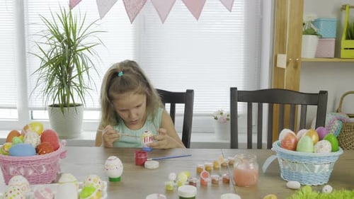 Mädchen färbt Eier für den hellen Feiertag Ostern bei sich zu Hause