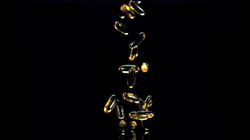Golden Capsules Falling in Slow Motion on Black
