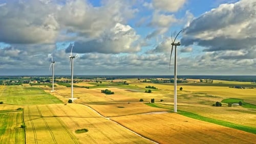 Luftaufnahme von Windkraftanlagen auf goldenem Feld im Sommer
