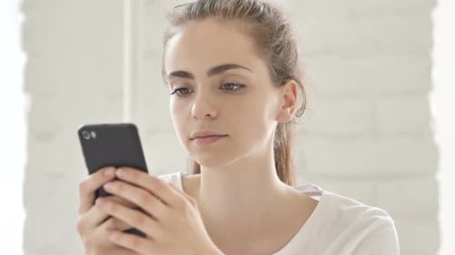 Young Woman Using Smartphone in Office