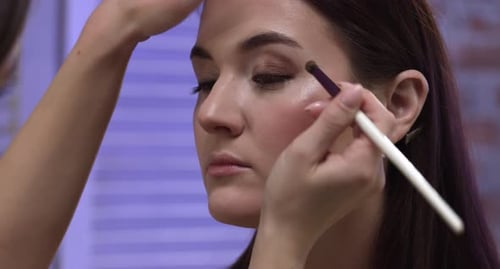 Applying Eyeshadow to Woman in Bright Light