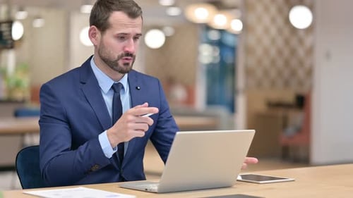 Businessman Doing Video Call on Laptop in Office