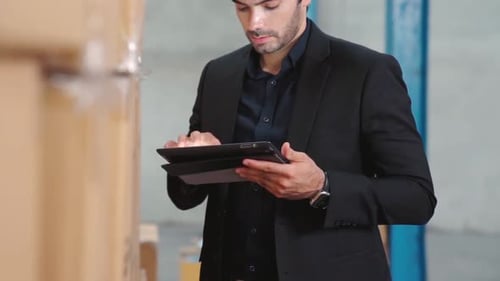 Factory Manager Using Tablet Computer in Warehouse or Factory