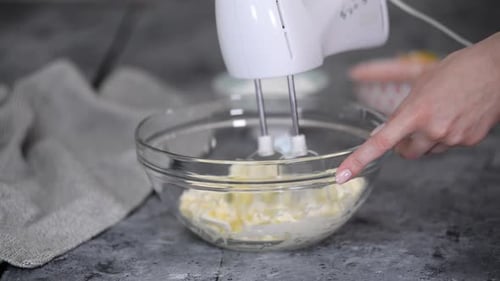 Mixing Butter with Electric Beater in Glass Bowl