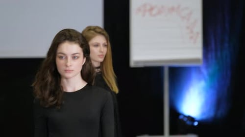 Une fille brune sur le podium pendant la semaine des défilés de mode