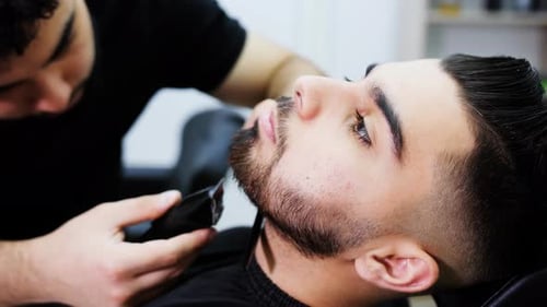 Barber Trimming Beard in Upscale Barber Shop