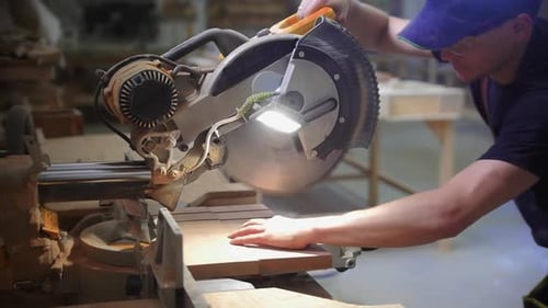 Carpentry Workshop Man Worker Cutting Notches on the Wooden Desk Using a Big Circular Saw