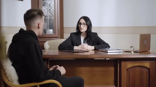 Portrait of Confident Professional Female Psychologist Talking To Depressed Man in Office