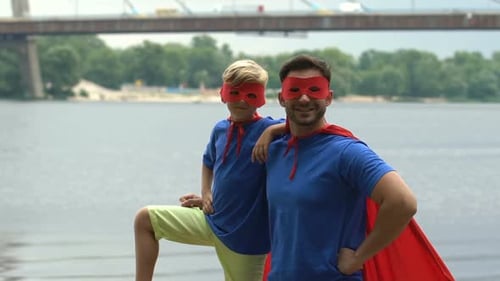 Father and Son Dressed as Superheroes Near River