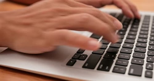 Hands Typing on Keyboard at Workplace
